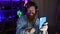 Grinning gaming wizard! young irish redhead man streamer confidently hosts epic video call via smartphone in heart of night-dark
