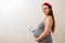 Grinning pregnant woman with small box