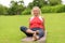 Grinning senior woman sitting on yoga mat