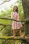 Grinning teenage girl standing on branch of an old tree