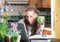 Grinning woman in kitchen with homework and laptop