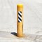 Gritty Yellow Safety Bollard on Concrete Pavement