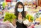 Groceries shooping during covid-19 virus quarantine - young beautiful and positive Asian Chinese woman in mask carrying vegetables