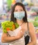 Groceries shooping during covid-19 virus quarantine - young beautiful and positive Asian Korean woman in mask carrying vegetables