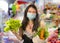 Groceries shooping during covid-19 virus quarantine - young beautiful and positive Asian Korean woman in mask carrying vegetables