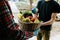 A grocery store delivery man wearing a black polo-shirt delivering food to an old man at home