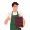 Grocery store employees,small business.A cheerful young seller holds a paper package for shopping in his hands. Offers