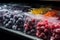 Grocery store shelf lined with plastic bags of frosty, delicious frozen berries