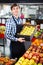 Grocery worker selling seasonal fruits