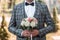 The groom adjusts his jacket, groom in a jacket, Groom in gray tuxedo and bowtie correct his buttons on white shirt. Wedding.