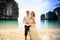 groom blonde curly bride in fluffy stand join hands on beach