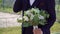 Groom in a blue suit with a bouquet of flowers of white roses.