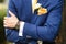 The groom in blue suit, watch and boutonniere