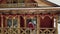 Groom and bride drink coffee on a balcony of wooden log chalet cottage in village while drone camera flies away