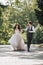 Groom and bride in the garden. Spring wedding in the park. Happy wedding couple running in the park. Stylish and beautiful.