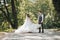 Groom and bride in the garden. Spring wedding in the park. Happy wedding couple running in the park. Stylish and beautiful.