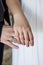 Groom and bride holding hands with wedding rings