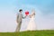 Groom and bride keep heart-shaped balloon