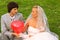 Groom and bride keep red balloon heart