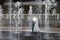 Groom and bride next to a fountain and water jets