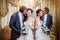 Groom and the bride stand near a mirror with a gold frame