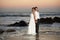 Groom and bride stand in sea water