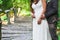 Groom and bride stand in summer park, cropped image