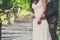 Groom and bride stand in summer park, cropped image