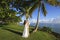Groom and bride standing by palm tree
