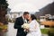 Groom and bride walking in the park on their wedding day. Autumn weather. Rair. Couple umbrella