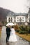 Groom and bride walking in the park on their wedding day. Autumn weather. Rair. Couple umbrella
