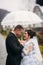 Groom and bride walking in the park on their wedding day. Autumn weather. Rair. Couple umbrella
