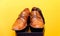 Groom brown wedding shoes on speaker. Yellow background.
