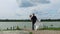 Groom circling bride in his arms on pier at lake. copy space