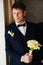 the groom is in a dark blue suit with a boutonniere and a bouquet of callas.