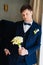 the groom is in a dark blue suit with a boutonniere and a bouquet of callas.