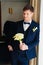 the groom is in a dark blue suit with a boutonniere and a bouquet of callas.