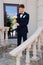 the groom is in a dark blue suit with a boutonniere and a bouquet of callas.