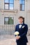 the groom is in a dark blue suit with a boutonniere and a bouquet of callas.