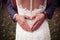 A groom doing a heart shape with his hands on his wife`s back