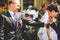 Groom drinks soda from a bottle held by his friend