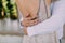 Groom embrace woman by the waist. Artwork. Soft focus. Beautiful tanned bride in a beige fitting dress and groom in a