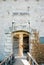 Groom embraces bride behind the ajar wooden door of Mamula Fort