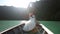 groom embraces bride sitting in longtail boat