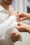 A groom fastening a cuff-link