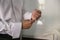 Groom fastens cufflinks on the cuff of his white shirt