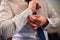 Groom fastens cufflinks on the sleeve of a white shirt on the wedding day