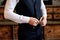 Groom fastens wedding jacket, close-up