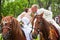 A groom and fiancee sit on horse