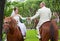 A groom and fiancee sit on horse